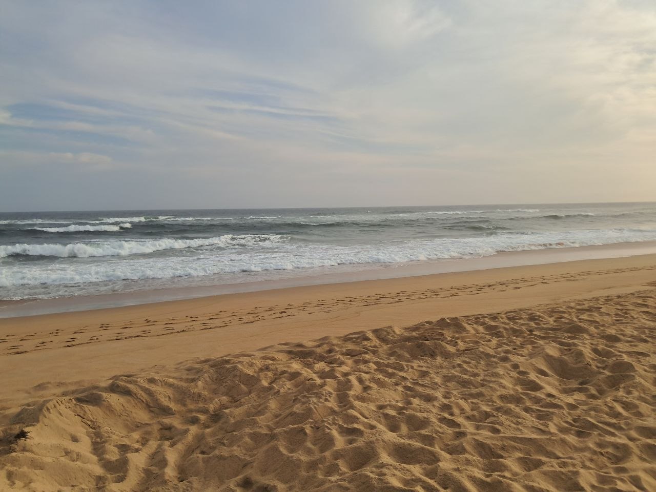 Wilderness Beach at sunset with rippled, footprint-marked sand